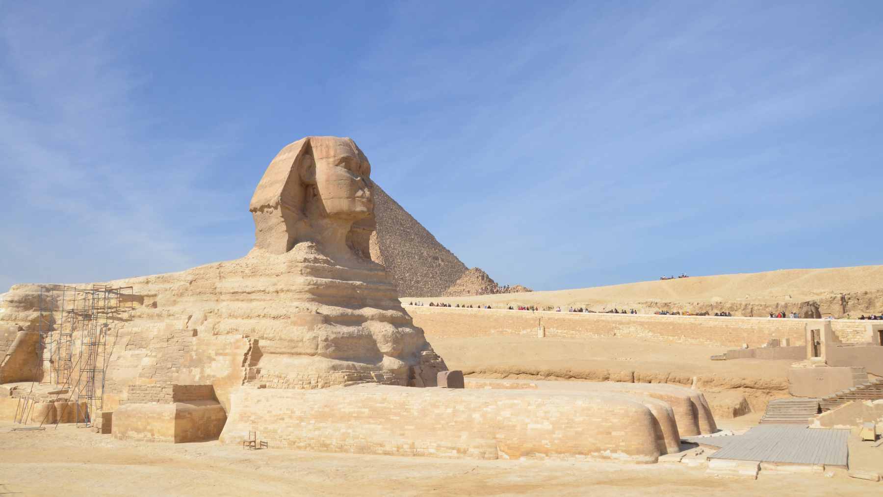 An aerial view of the Giza Plateau showing the Great Sphinx, the pyramids, and surrounding sandy terrain.