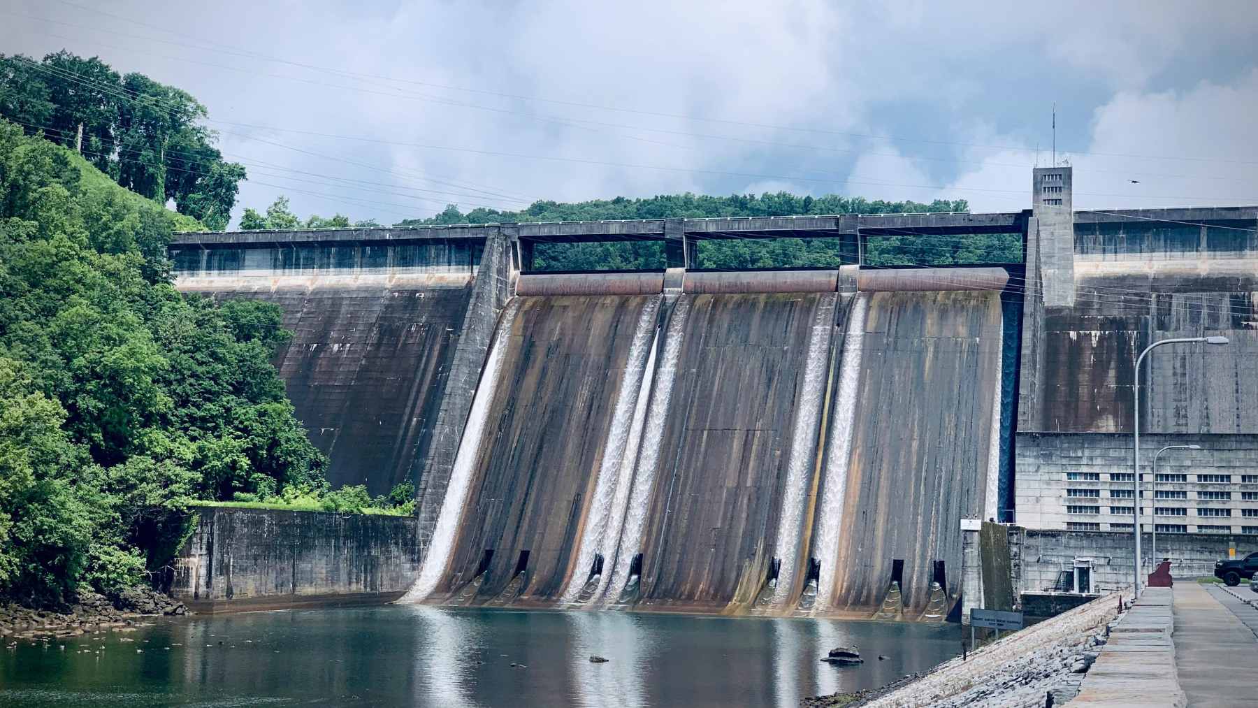 An aerial view of an aging hydroelectric river dam in Michigan, similar to the 13 structures Consumers Energy proposes to sell for $1.