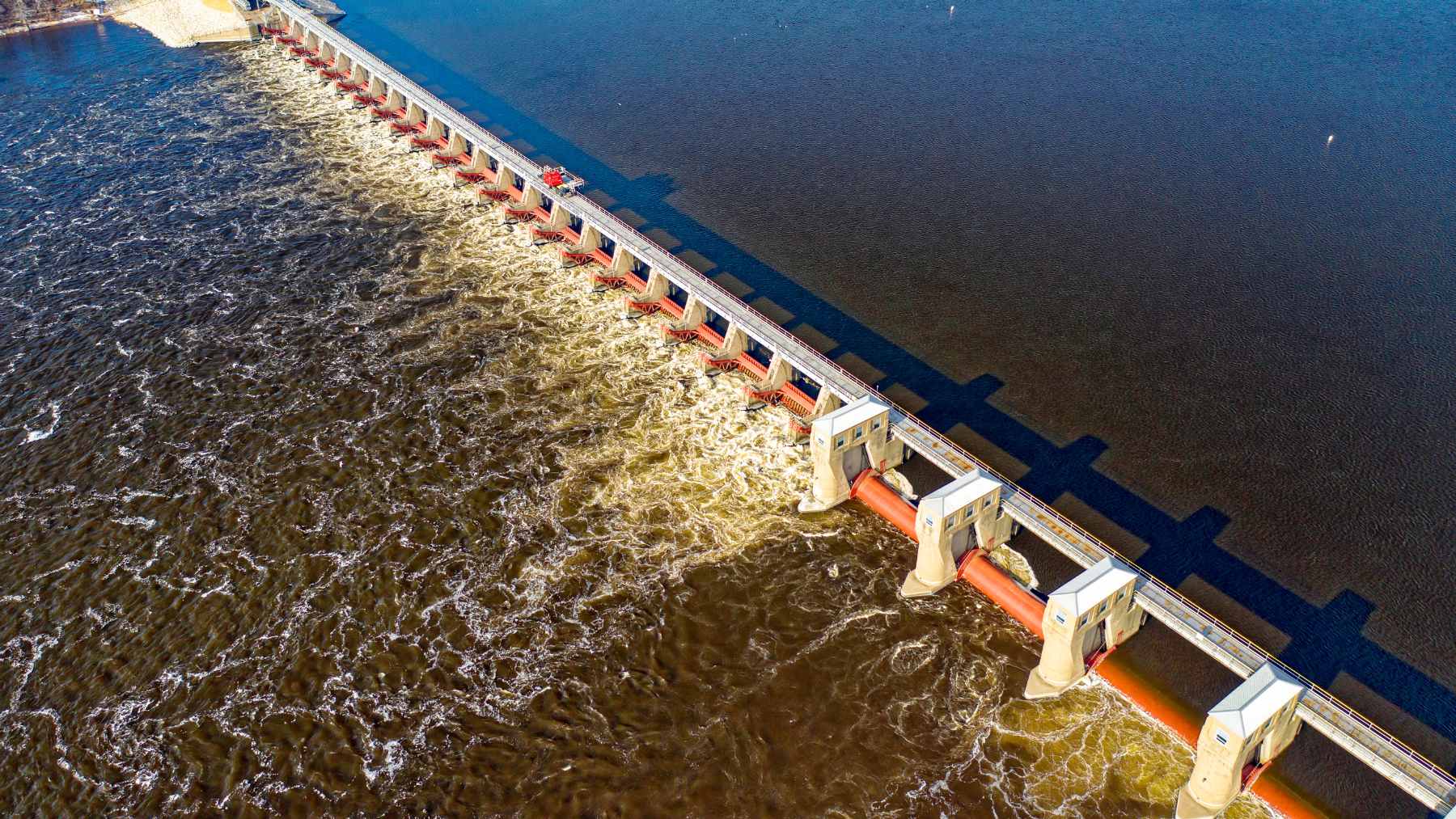 An aerial view of an aging hydroelectric river dam in Michigan, similar to the 13 structures Consumers Energy proposes to sell for $1.