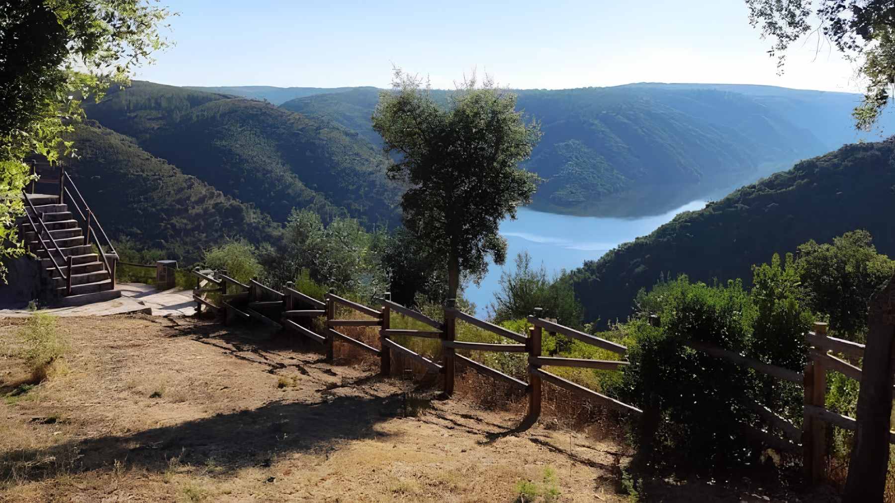 A modern twin-arch concrete bridge spanning the River Sever, connecting the rural border towns of Spain and Portugal.