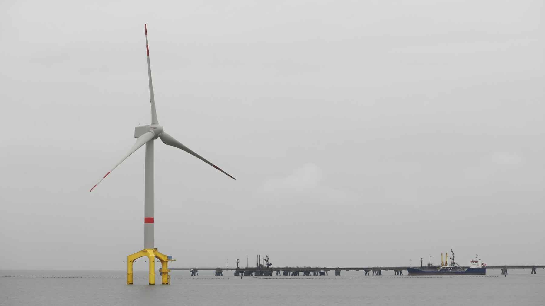 A 3D render of an Aikido Technologies floating wind turbine platform with integrated AI data center modules submerged in the ballast tanks.