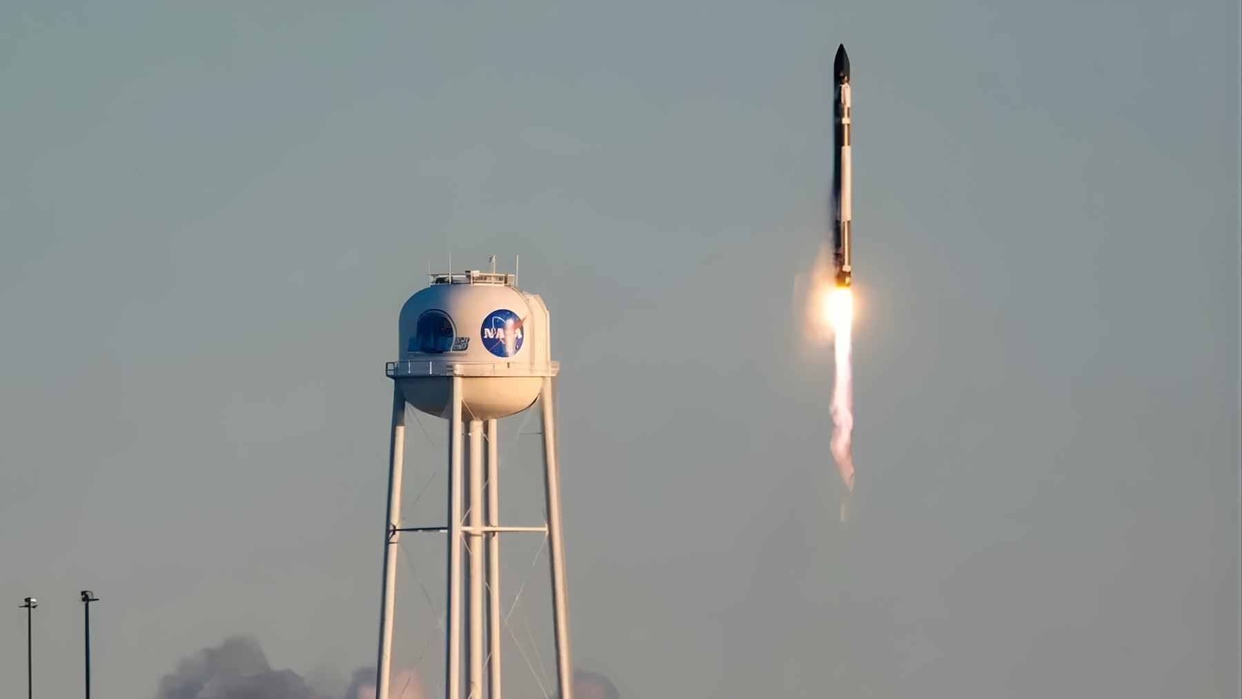 A Rocket Lab HASTE rocket launching from a coastal launchpad, ascending rapidly for a suborbital hypersonic test mission.