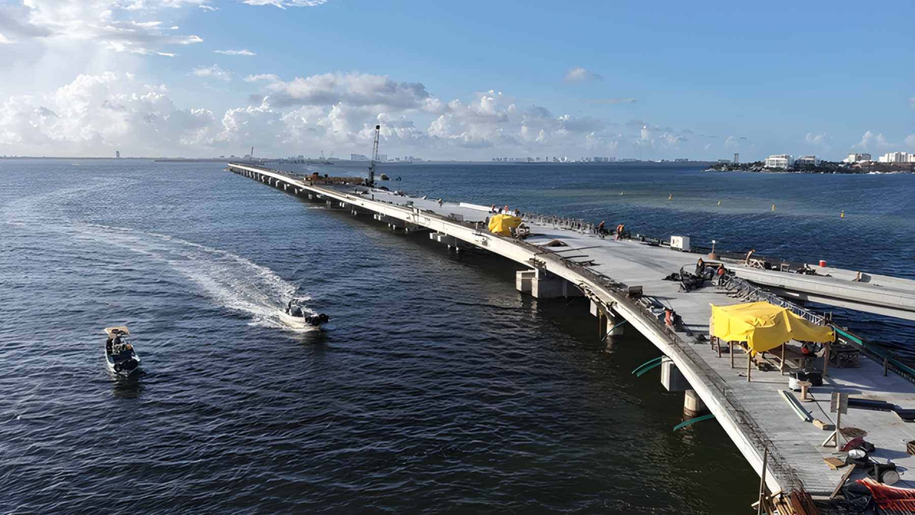An aerial view of the Puente Vehicular Nichupté under construction, stretching across the Nichupté Lagoon system to connect downtown Cancun with the Hotel Zone.