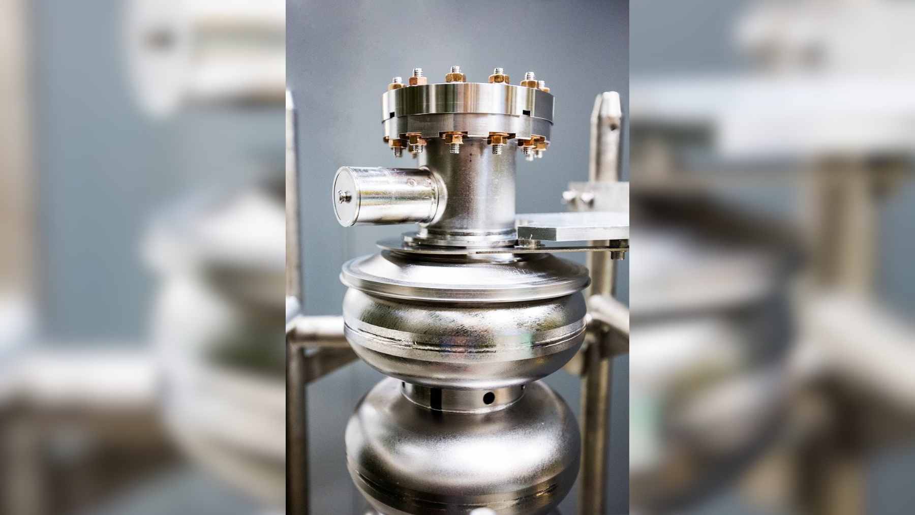 A high-tech superconducting particle accelerator glowing inside a specialized laboratory testing facility.