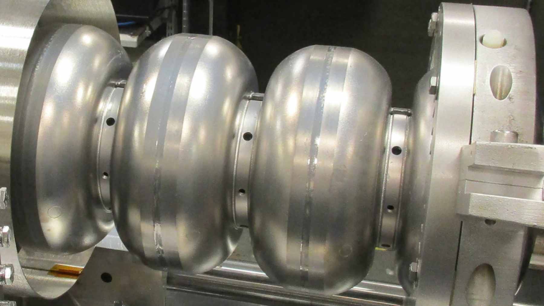 A high-tech superconducting particle accelerator glowing inside a specialized laboratory testing facility.