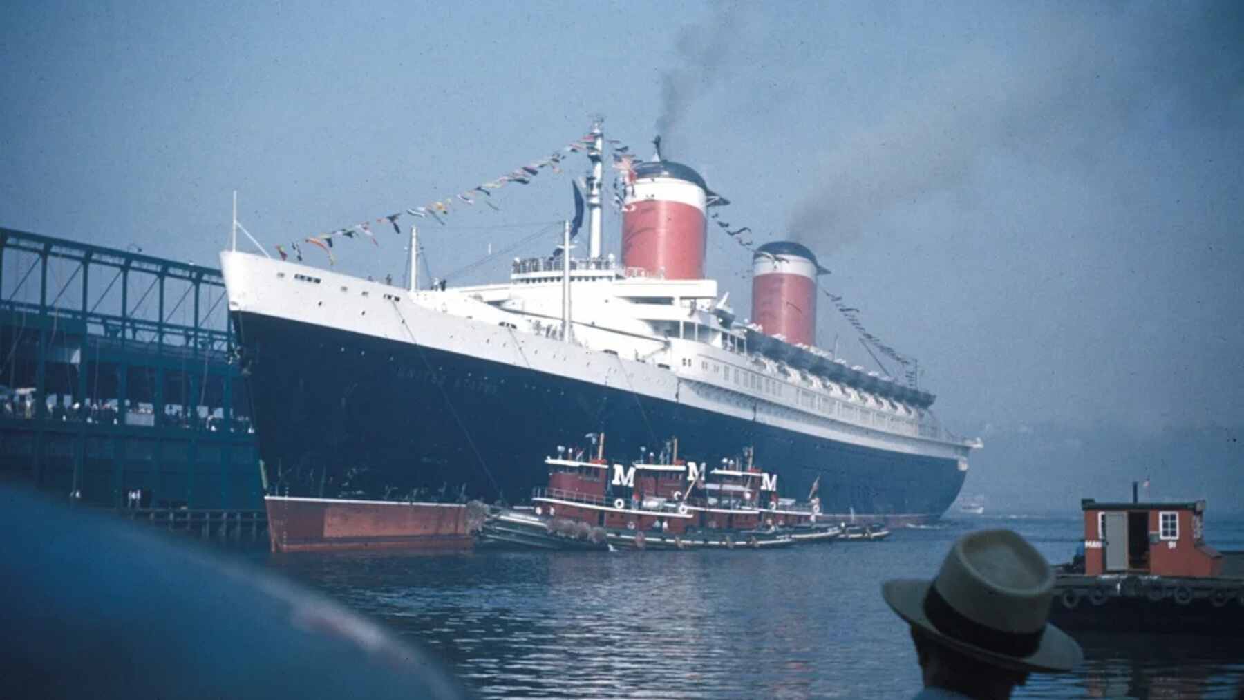 The massive SS United States ocean liner docked and undergoing environmental remediation before being deployed as an artificial reef.