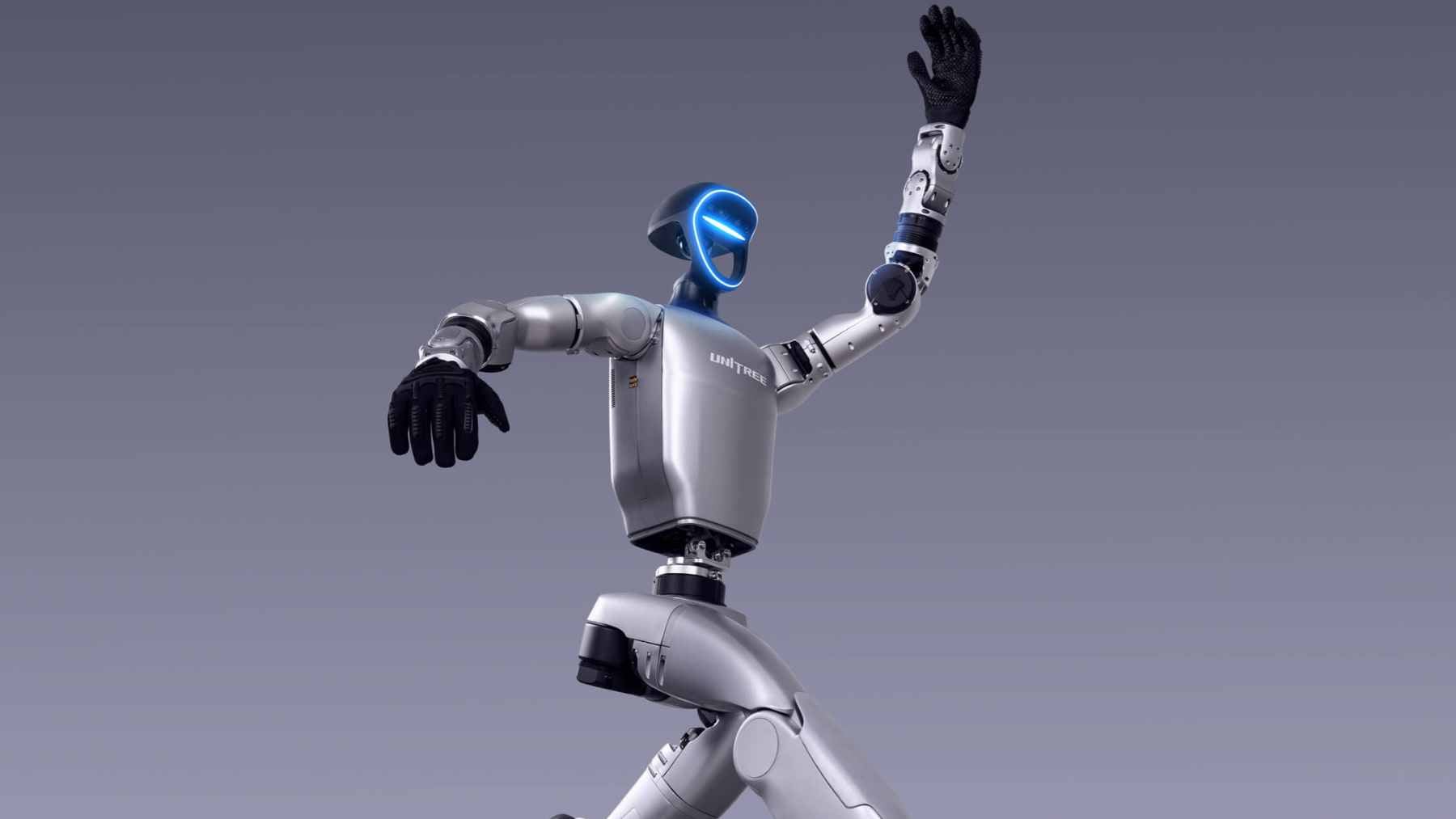 The Unitree R1 humanoid robot standing fully assembled next to its retail packaging.