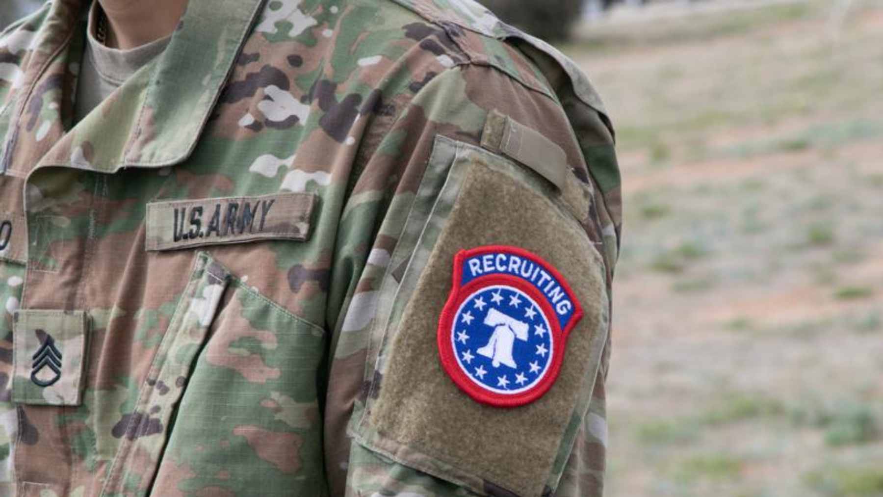 A young American man looking concerned while reading news about automatic Selective Service military registration on his smartphone.