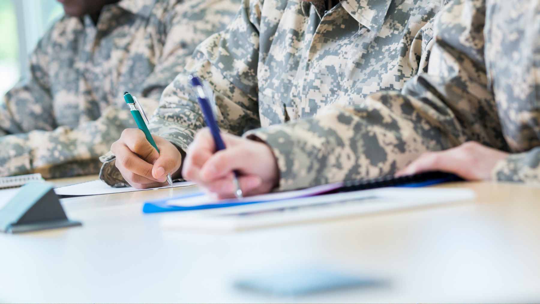 A close-up of a young man’s hands typing on a laptop, representing the shift to automated data integration for the Selective Service System.