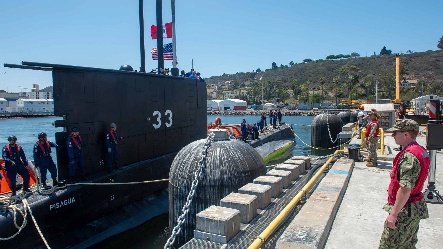 An aerial view of the bustling Callao Naval Base in Peru, featuring military docks and heavy port infrastructure.