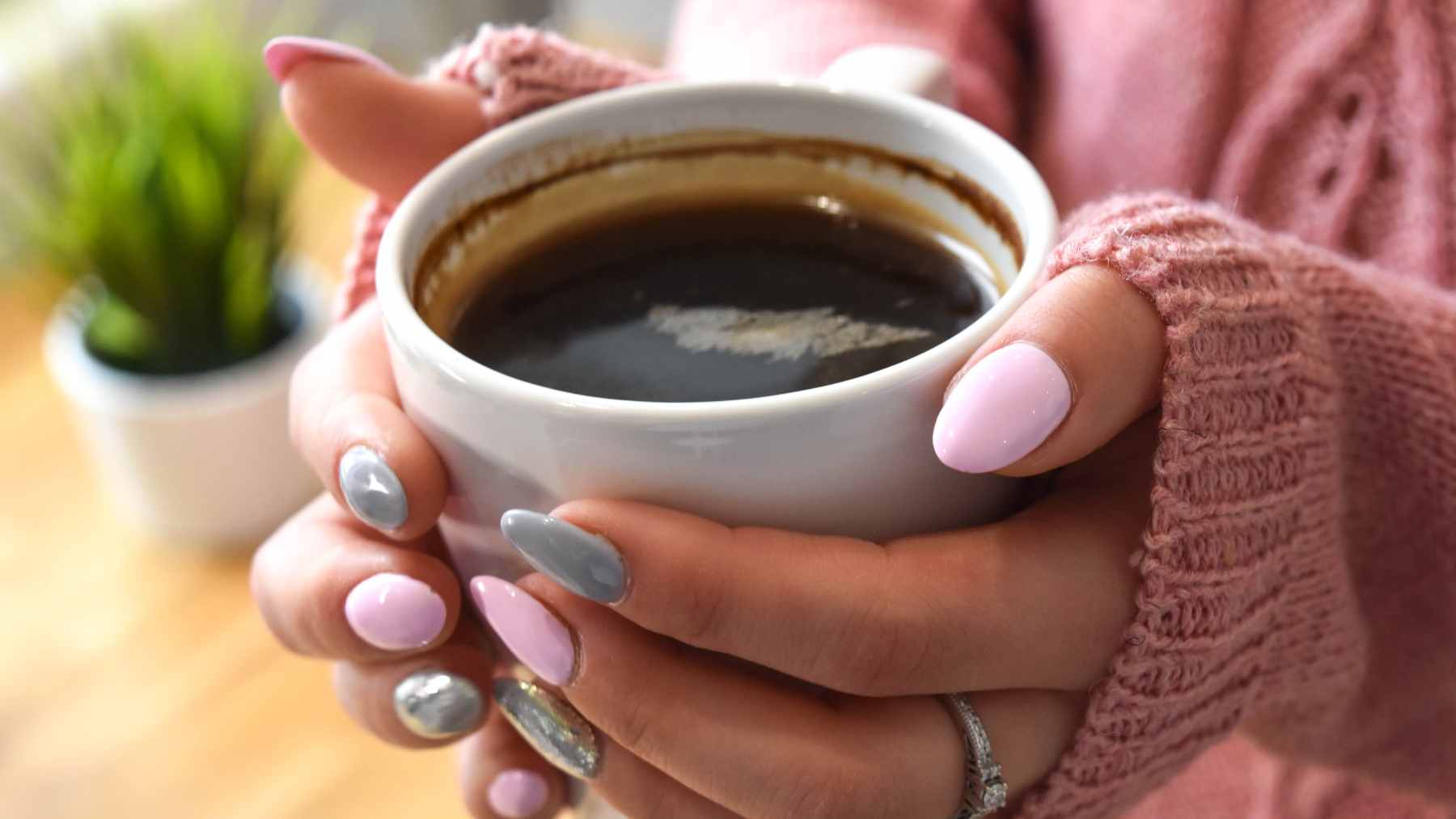 A close-up of used coffee grounds being processed in a laboratory beaker for biofuel extraction.