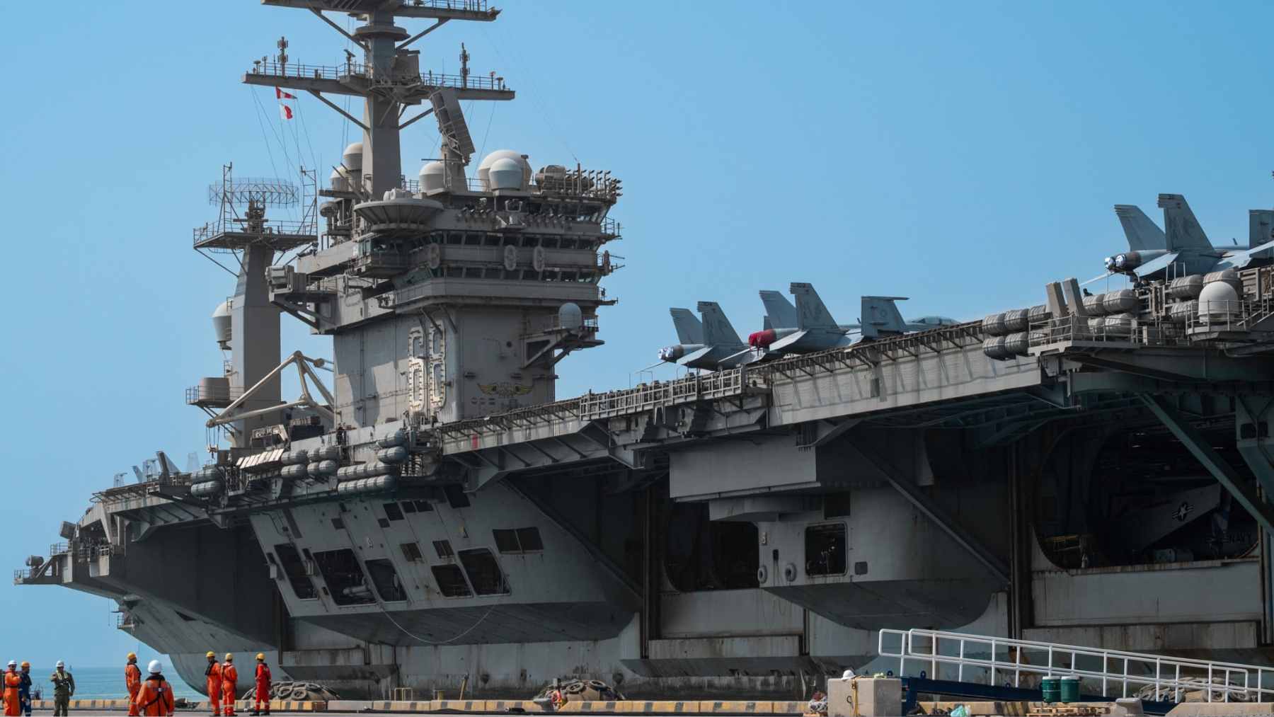 An aerial view of the USS Nimitz aircraft carrier navigating the ocean during its final deployment.