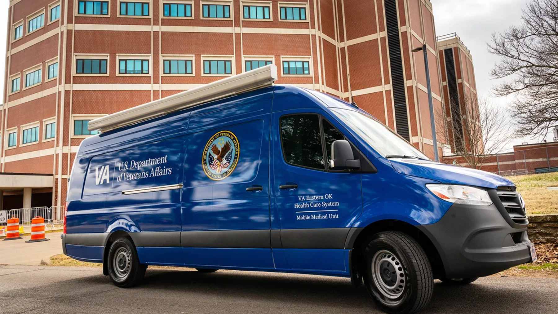 A veteran looking out the window of a shuttle bus while traveling a long distance on a rural highway.