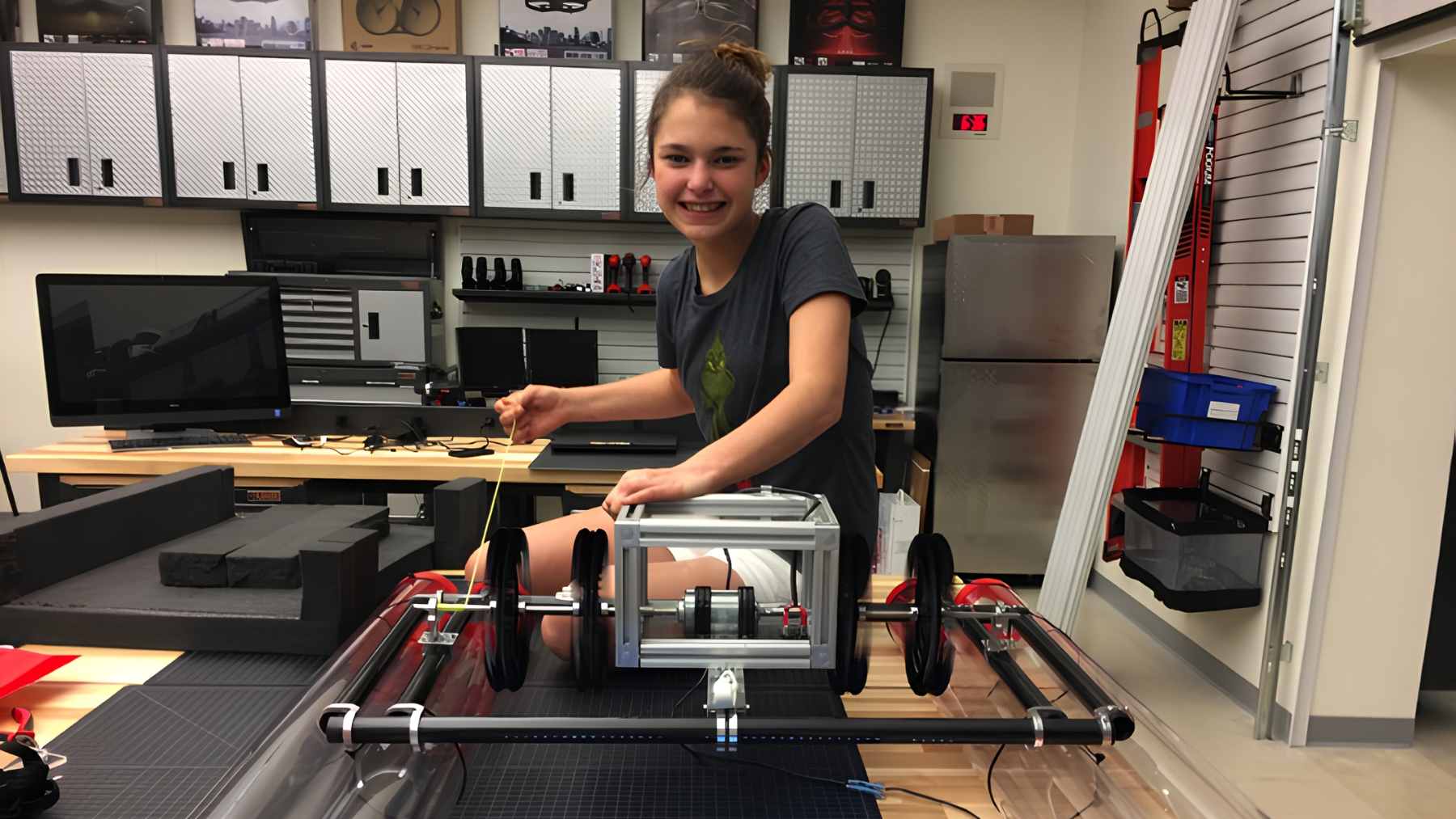 A 15-year-old girl demonstrating her $12 BEACON ocean current generator prototype, made from a PVC tube and a 3D-printed propeller.