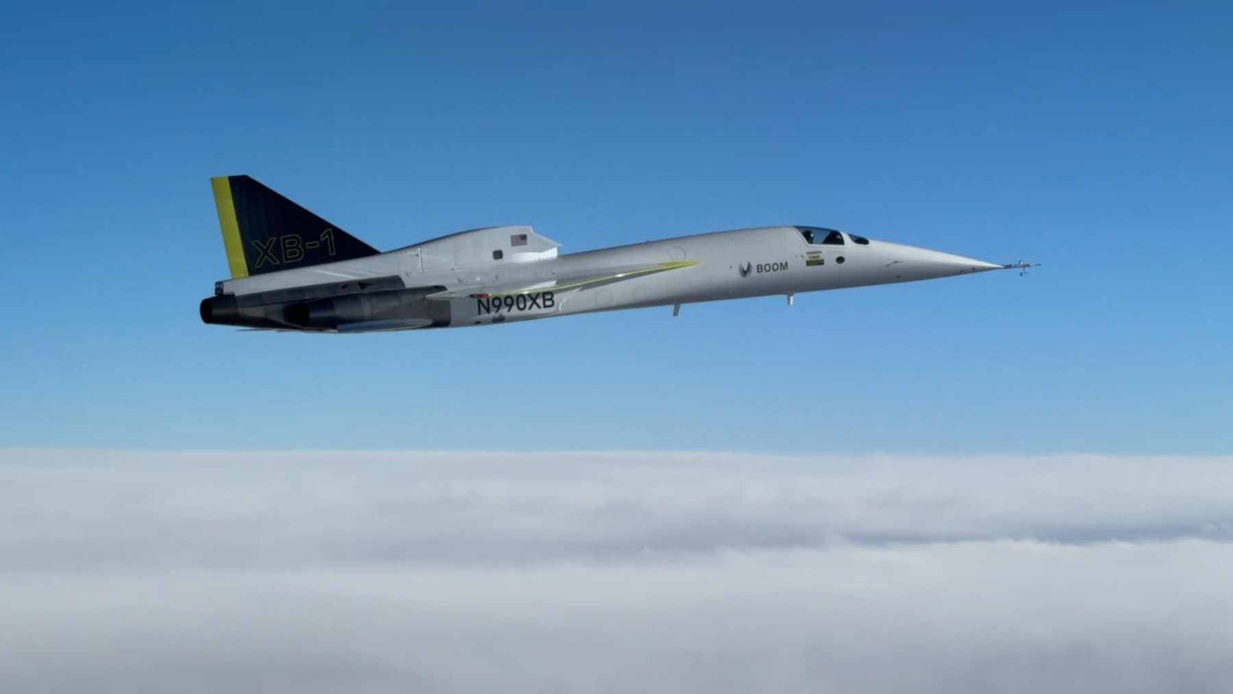 A sleek Boom Supersonic Overture passenger jet soaring high above the clouds in the upper stratosphere.