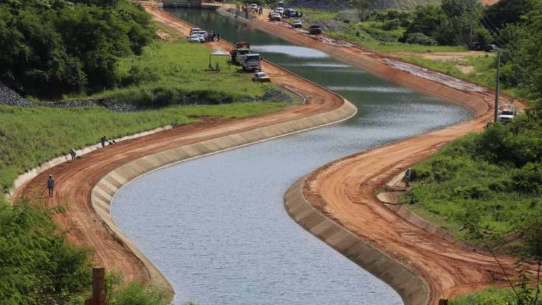 Construction progress of the Cinturão das Águas do Ceará artificial river canal system traversing dry landscape in Brazil.