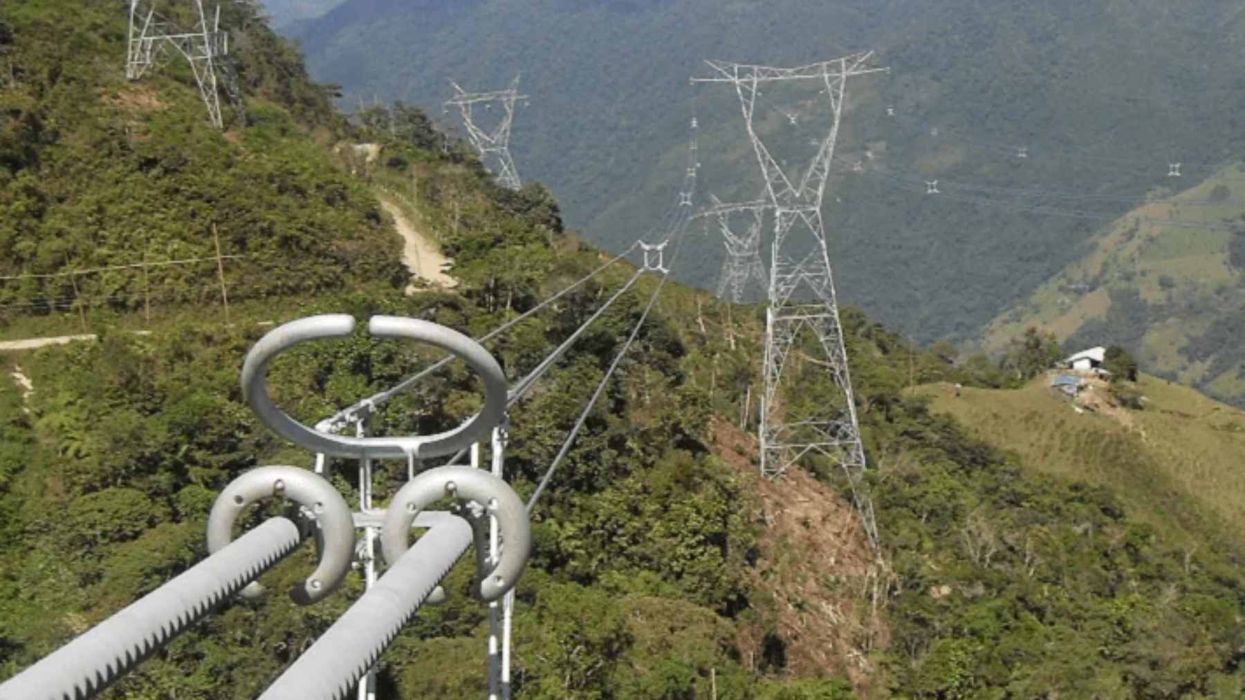 An aerial view of energy infrastructure and power transmission lines under a dry, sunny sky in Colombia.