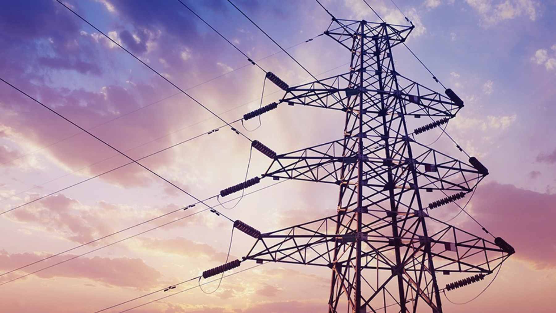 An aerial view of energy infrastructure and power transmission lines under a dry, sunny sky in Colombia.