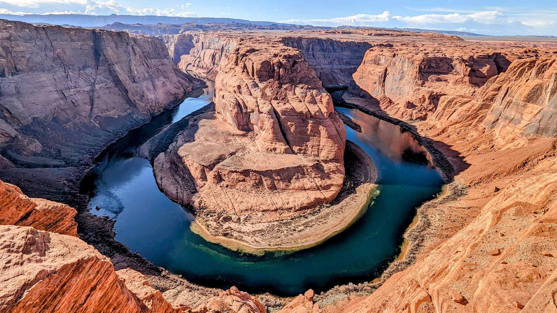 A view of Lake Powell showing starkly low water levels and the prominent "bathtub ring" on the canyon walls.