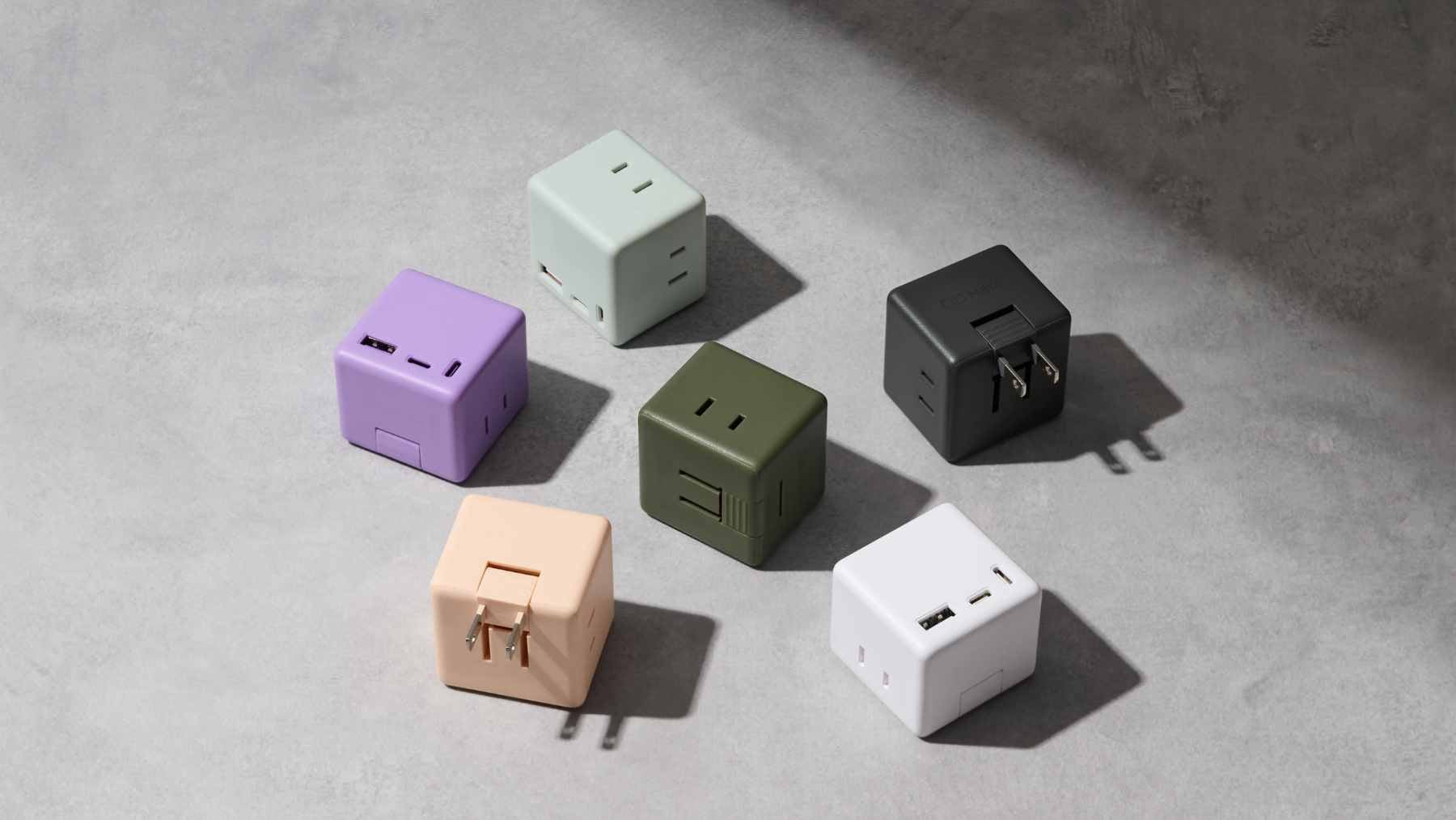 A white CIO Mate Tap001 cube-shaped power strip plugged into a wall outlet, featuring multiple USB ports and AC sockets.
