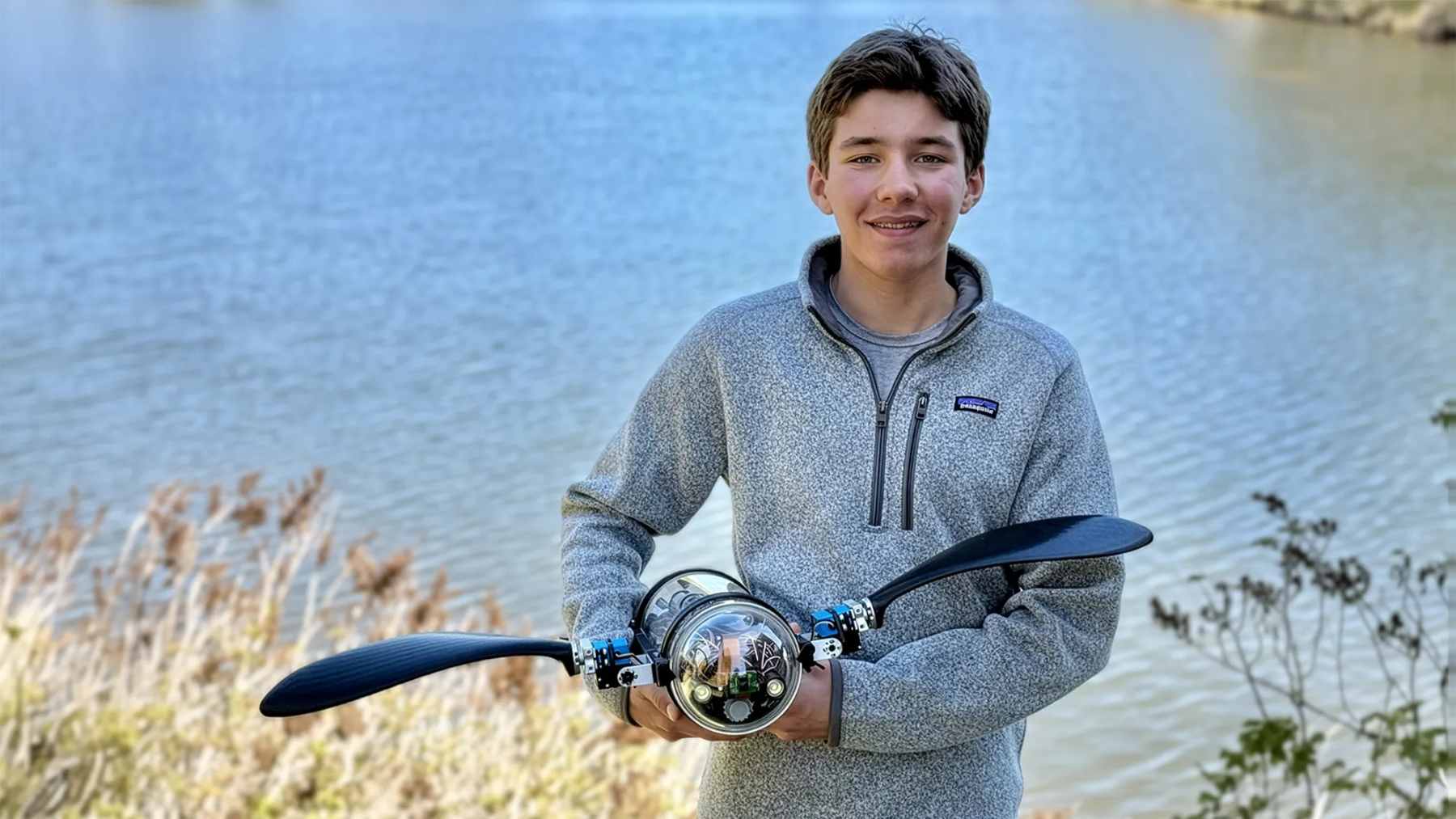 A close-up of Evan Budz’s bionic robotic turtle, BURT, showing the front propulsion flippers and acrylic body housing the AI sensor suite.