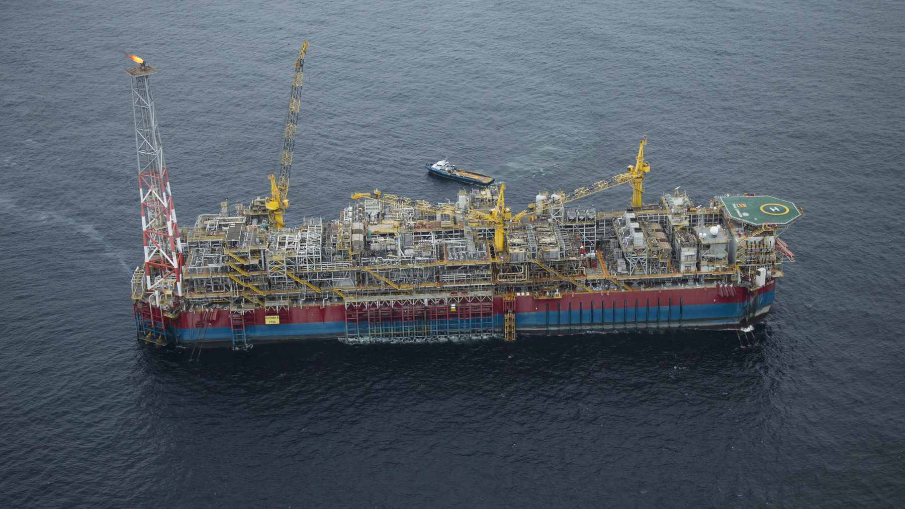 A deepwater drilling rig operating offshore, supported by logistics vessels in the Ionian Sea.