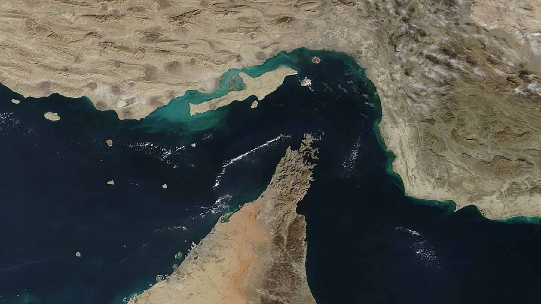 Aerial view of massive oil tankers navigating the narrow, congested waters of the Strait of Hormuz.