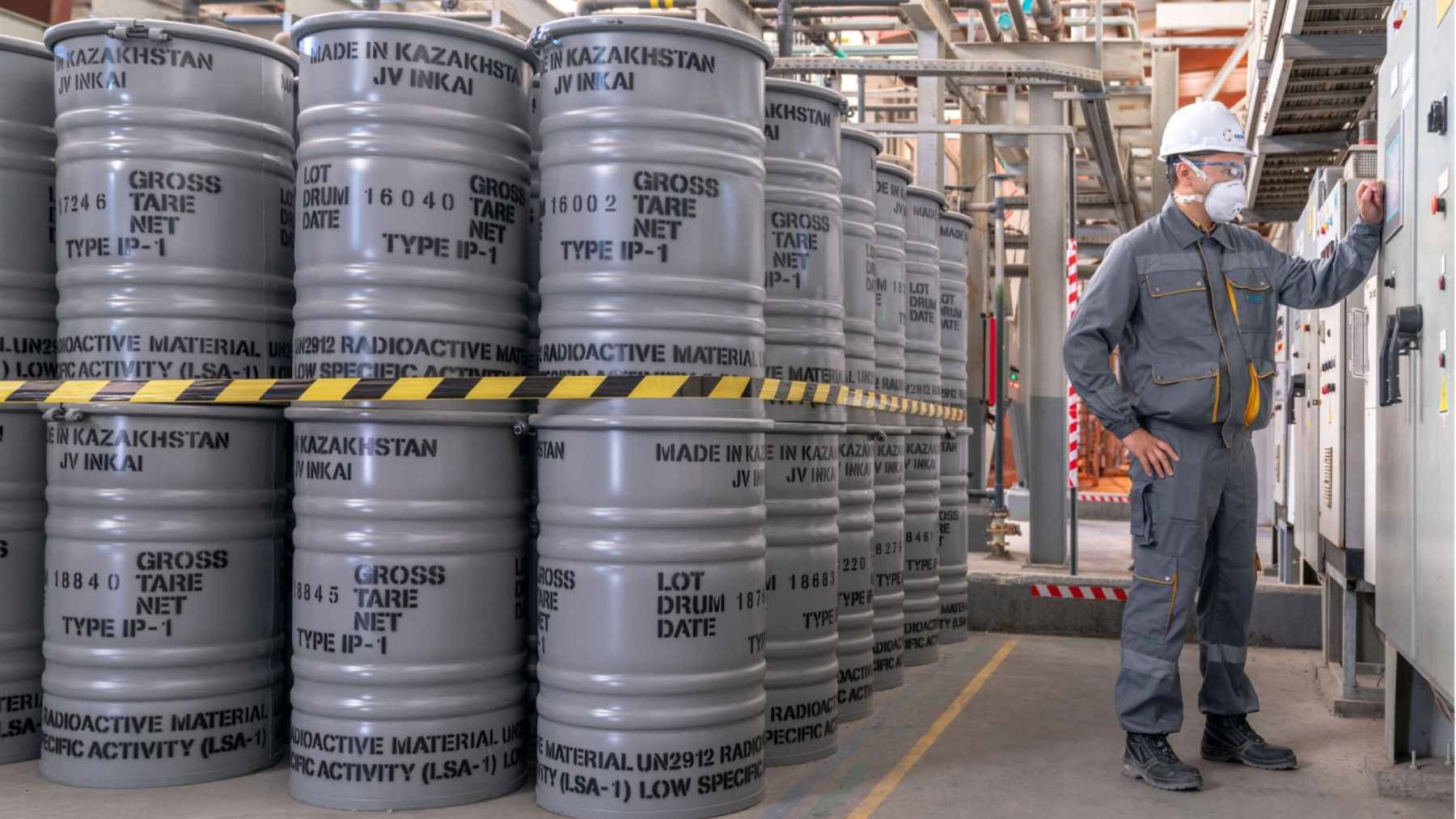 A close-up of natural uranium concentrate, known as yellowcake, being prepared for transport in an industrial facility.