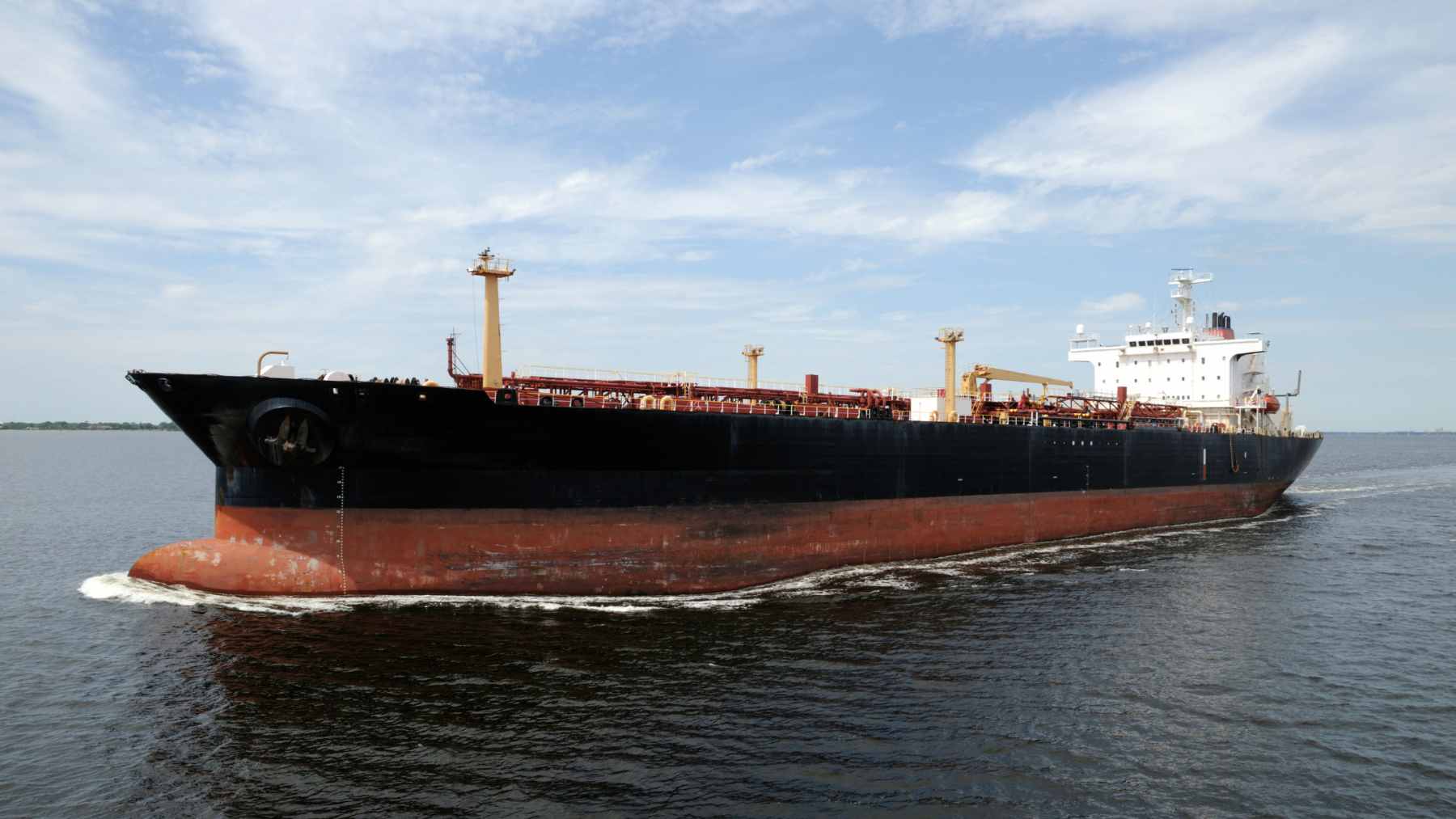 A large oil tanker navigating the open ocean, representing the strategic fuel shipment from Mexico to Japan.