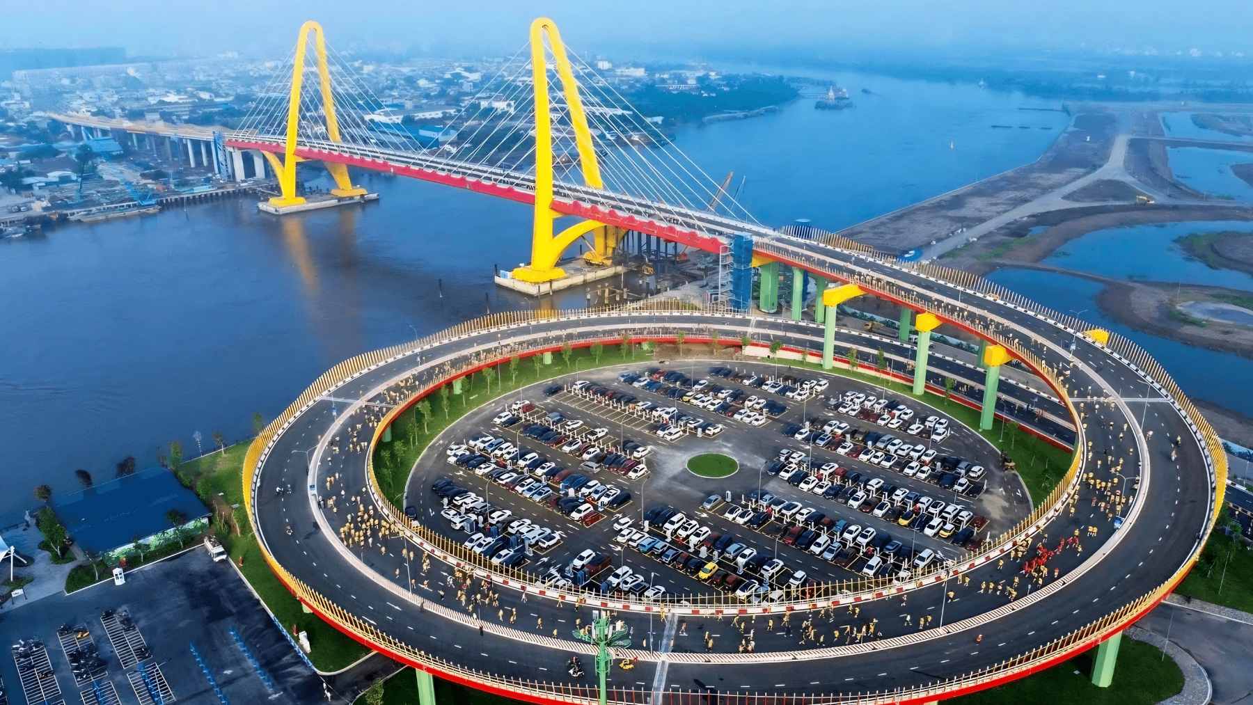 An aerial view of the newly completed Royal Bridge (May Chai Bridge) in Hai Phong, Vietnam, featuring its unique leaning twin-tower design over the Cam River.
