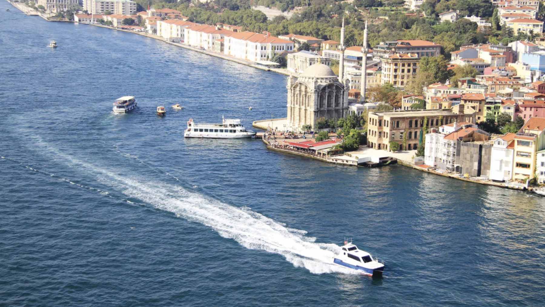 Aerial view of the narrow Bosphorus Strait in Istanbul crowded with massive cargo ships and oil tankers.