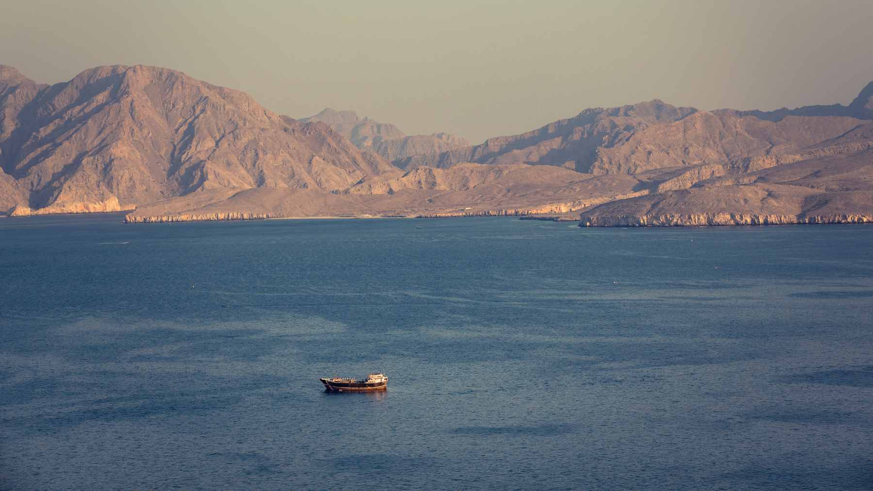 An aerial view of a crude oil tanker transiting the strategic maritime chokepoint of the Strait of Hormuz.