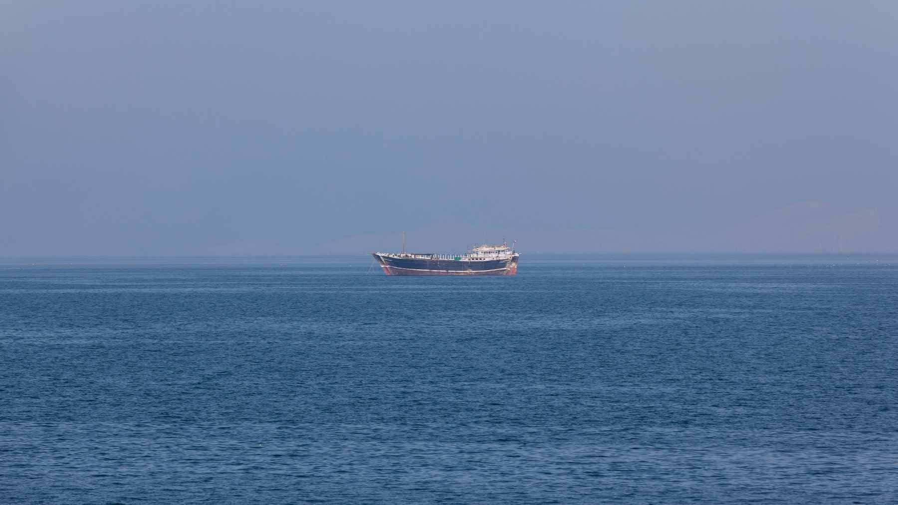 An aerial view of a crude oil tanker transiting the strategic maritime chokepoint of the Strait of Hormuz.