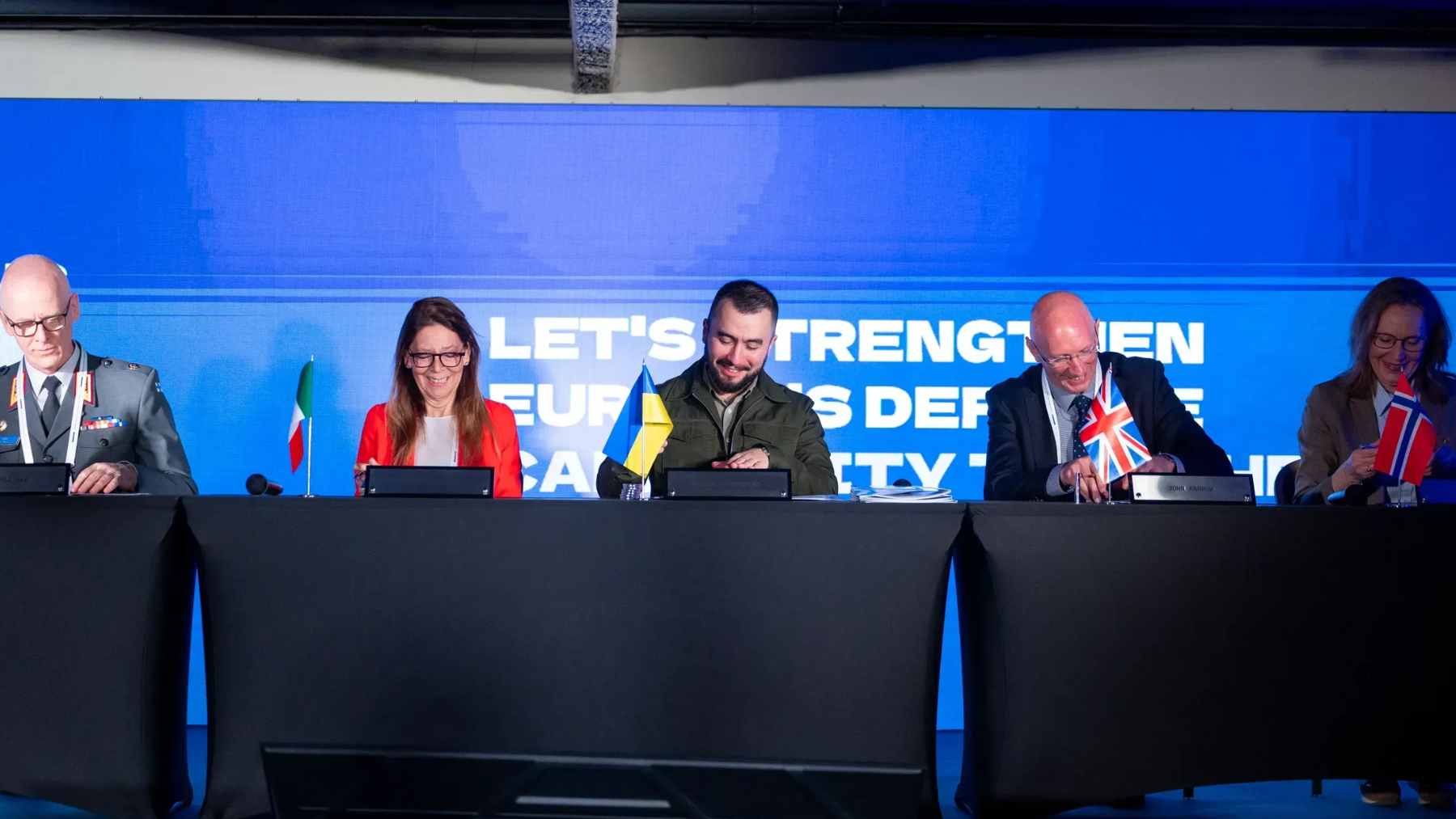 Representatives from Ukraine, Finland, Italy, Norway, Sweden, and the UK signing the CORPUS defense procurement memorandum in Kyiv.