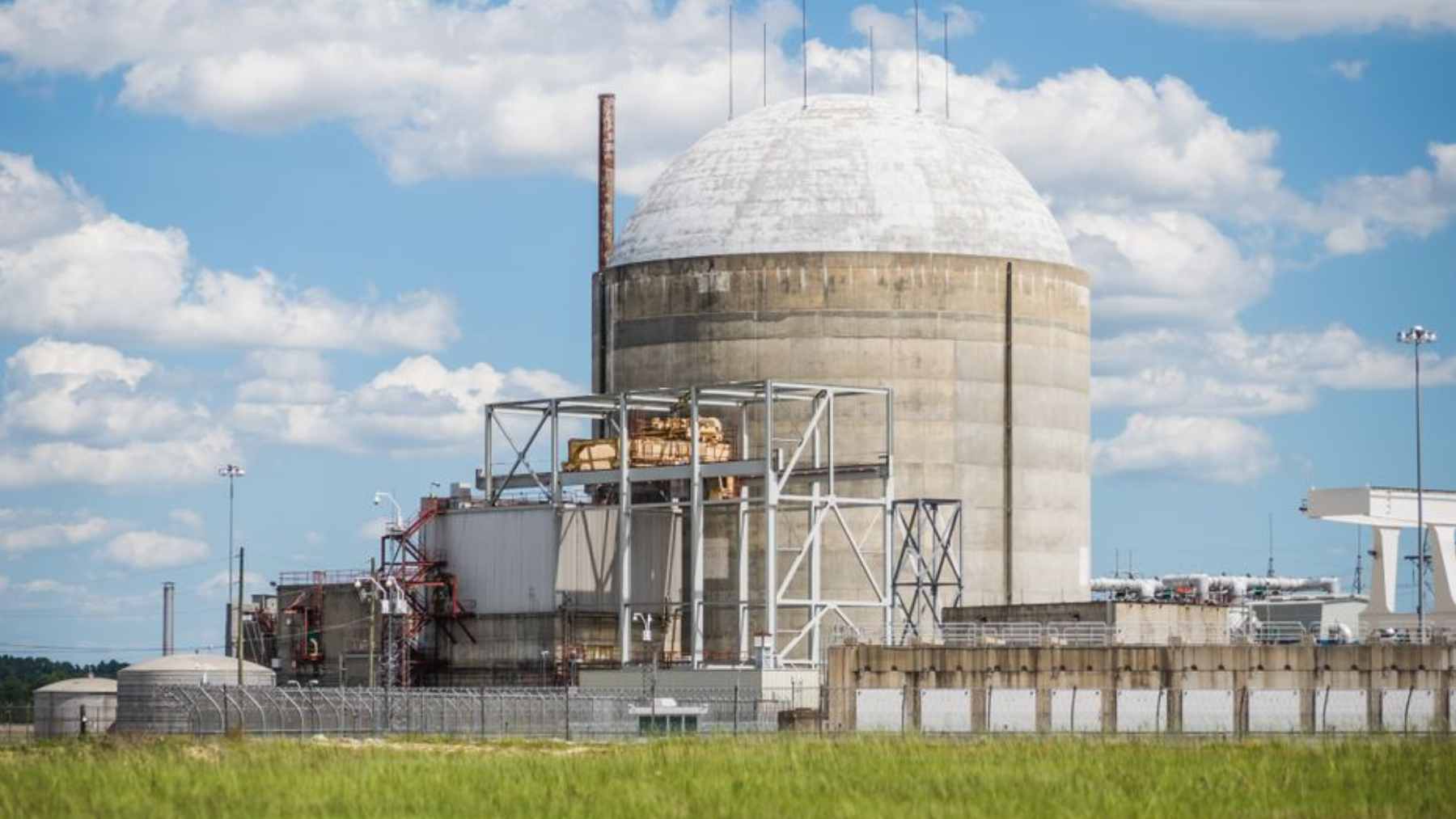 Exterior view of Duke Energy's H.B. Robinson Nuclear Plant in South Carolina, showing the reactor building and energy transmission infrastructure.
