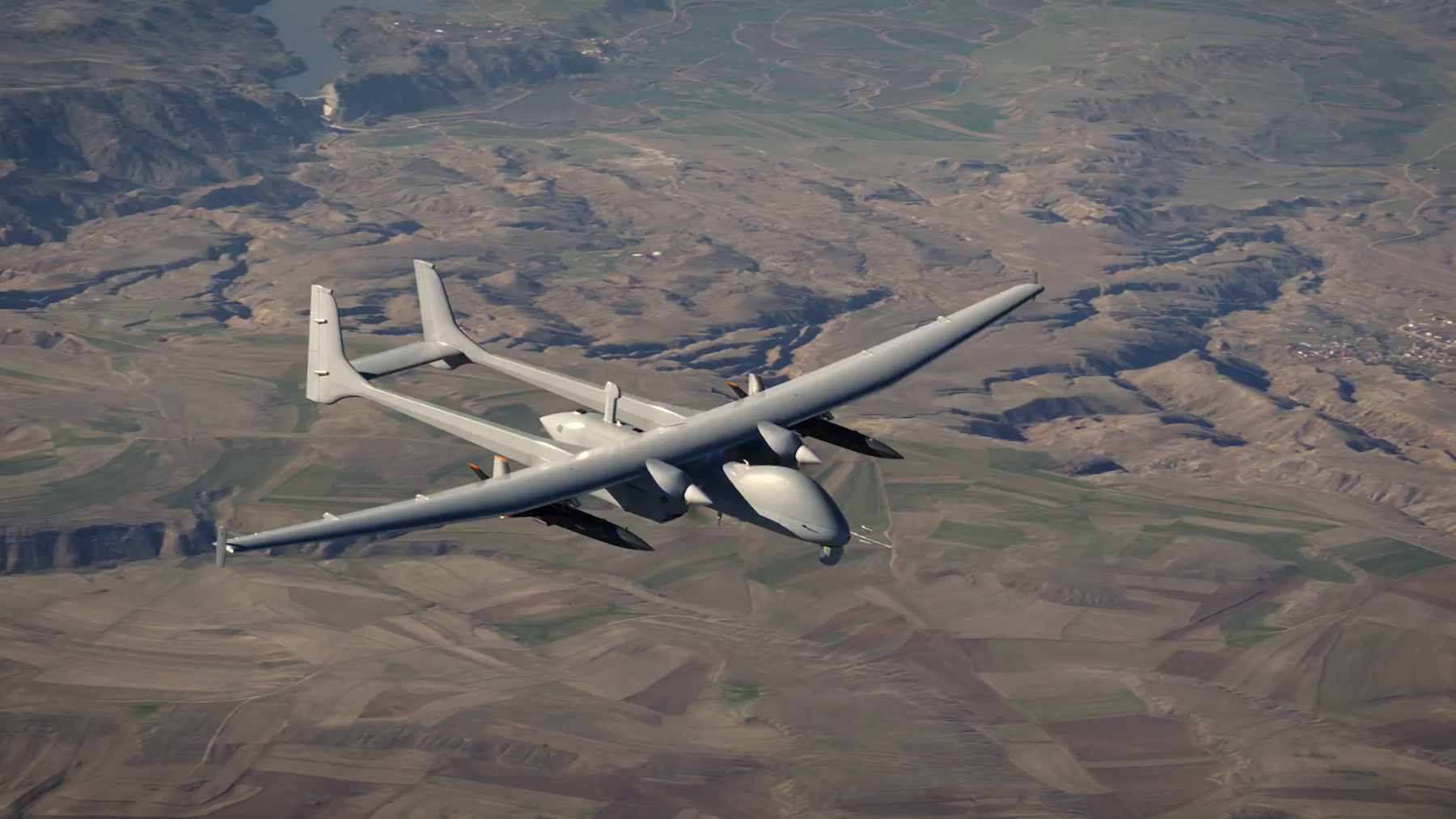 Turkish Aerospace Industries Aksungur UAV carrying two Süper Şimşek jet-powered drones under its wings during a flight test.