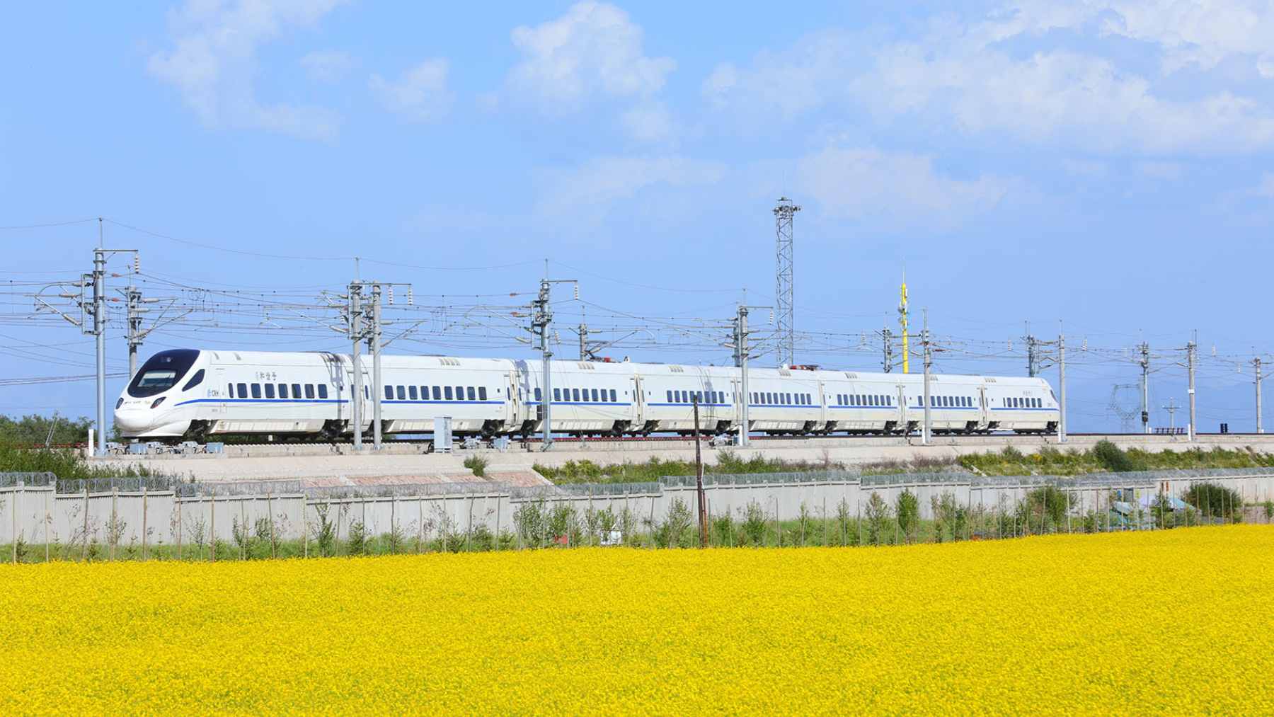A modern high-speed electric train traveling through a scenic landscape on China's expanding rail network.