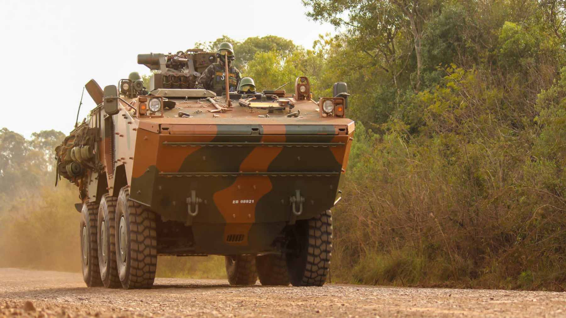 A Brazilian Army Guarani 6x6 amphibious armored troop carrier driving through a flooded area during rescue operations.