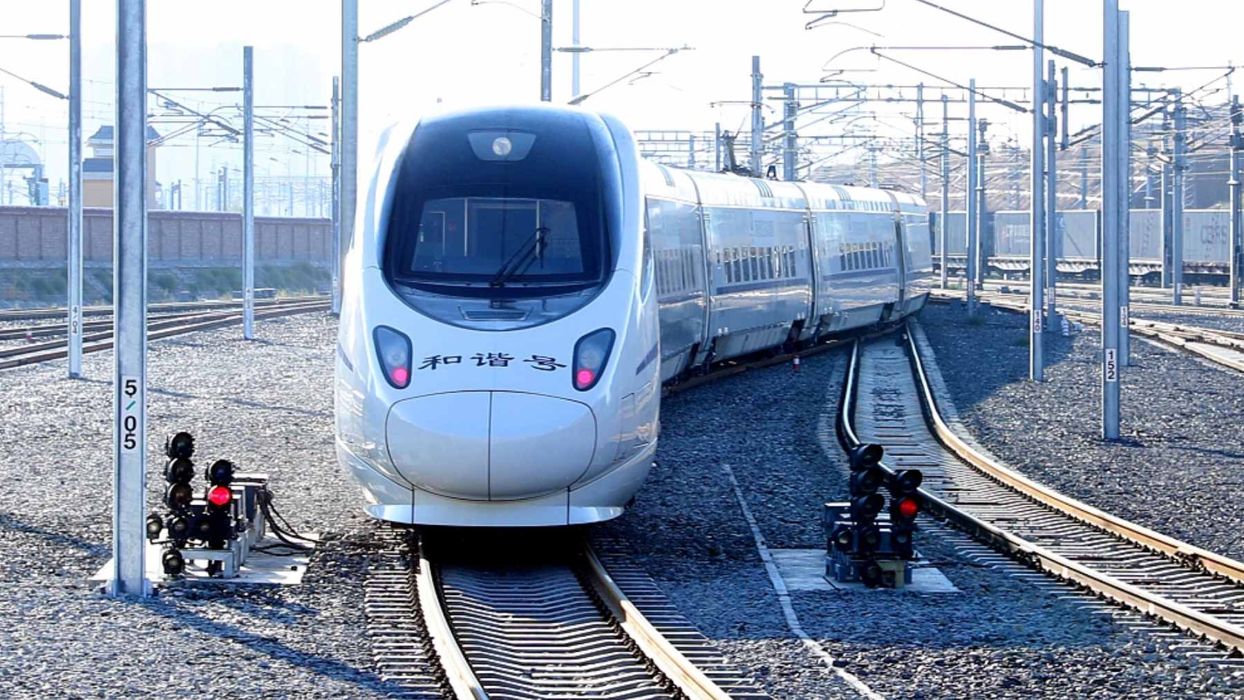 A sleek high-speed D-series train departing from Beijing, marking the new direct high-speed service to the Urumqi region.