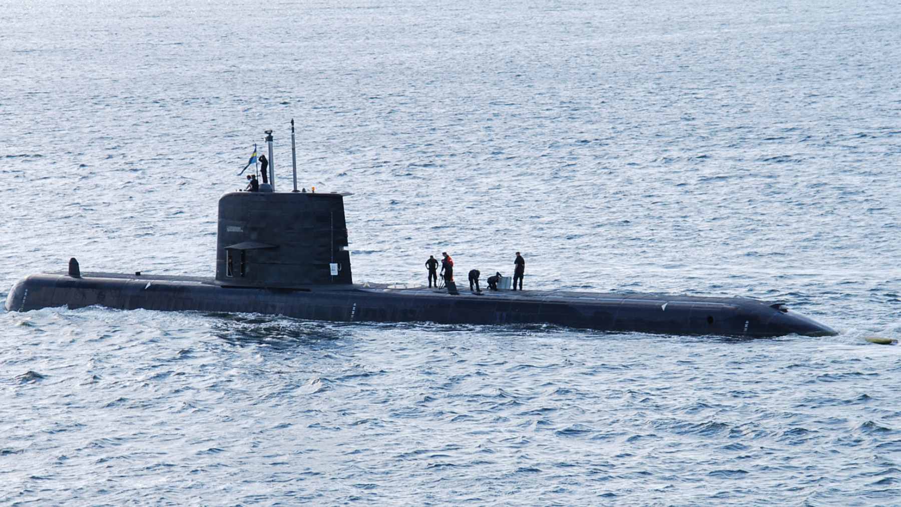 A newly launched, stealth-optimized Chinese nuclear submarine featuring an X-form rudder and a minimal sail structure at the Jiangnan Shipyard.