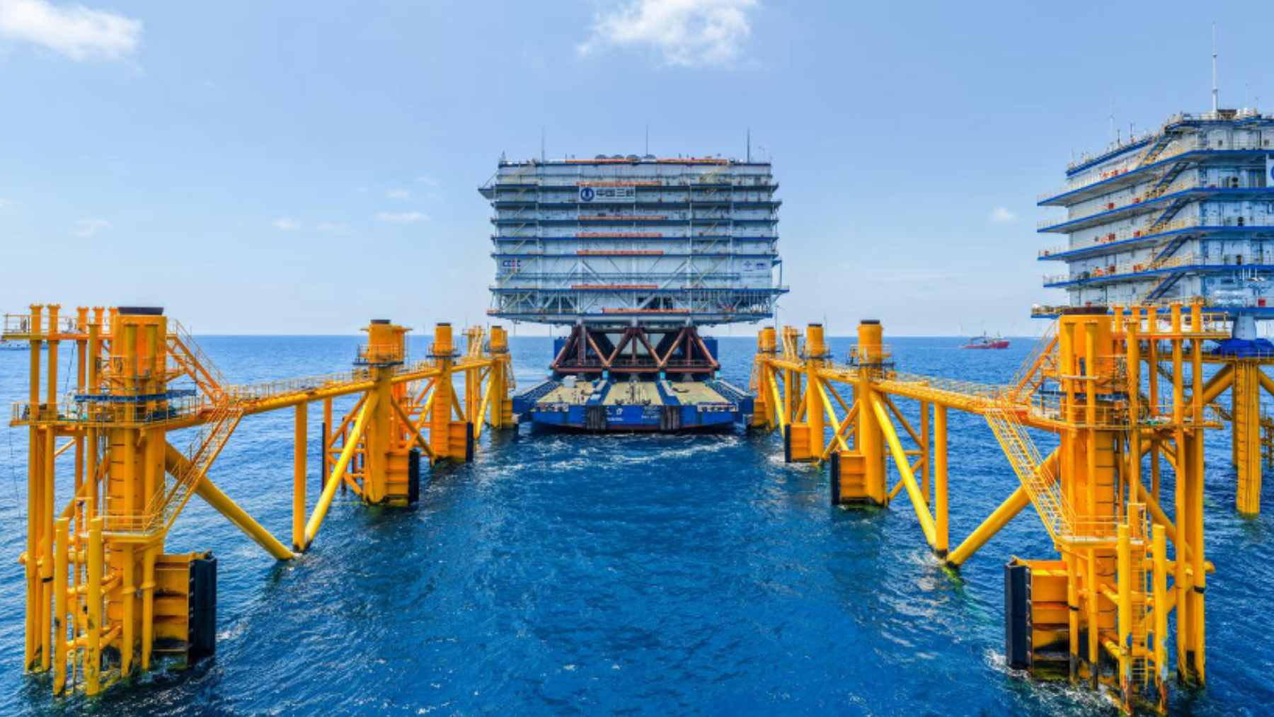 A massive offshore converter station platform being positioned at sea to support large-scale wind farm grid integration.