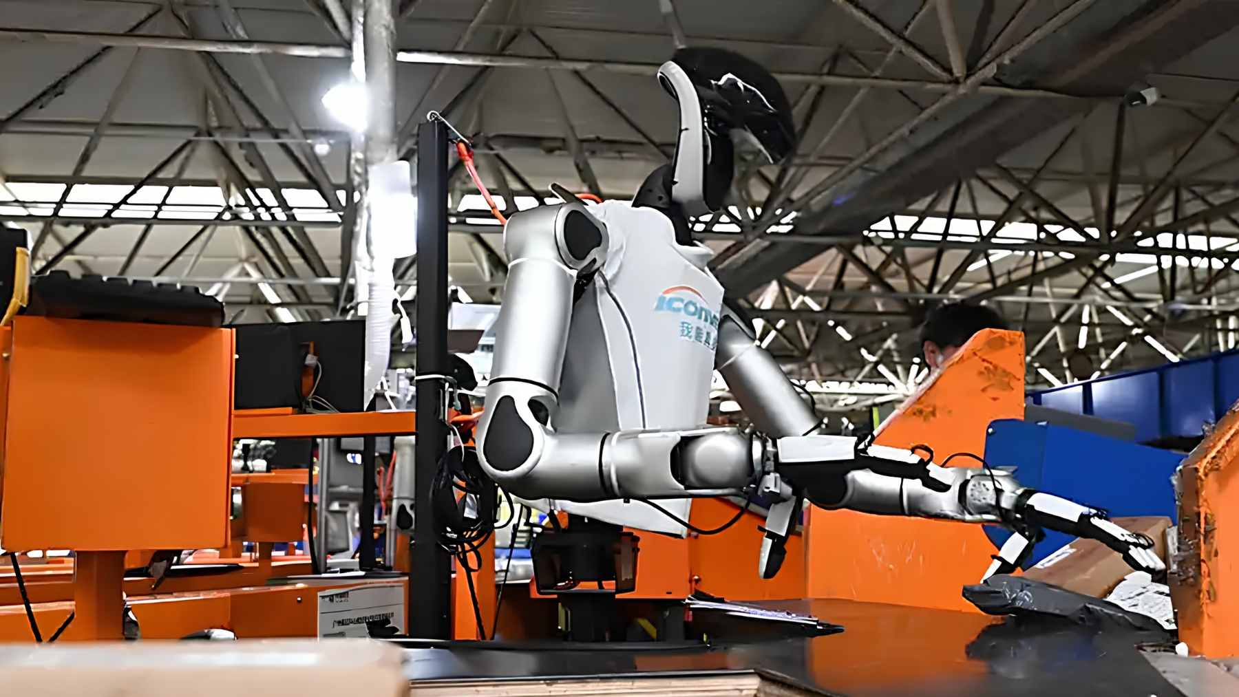 A RobotEra M7 humanoid robot performing parcel sorting tasks at a conveyor belt station in the Jianggao logistics center.