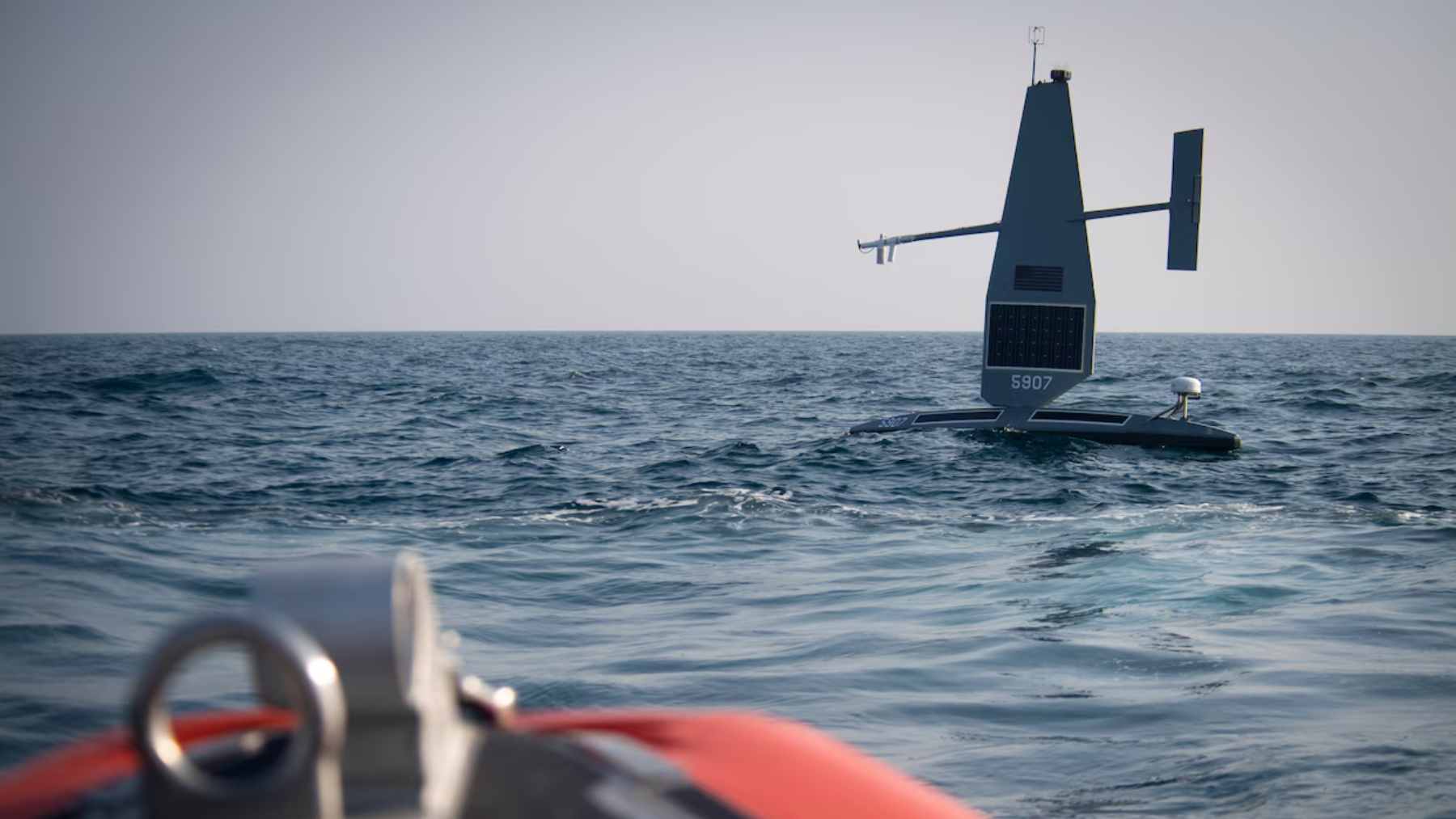 A 33-foot Saildrone autonomous vessel patrolling the open waters of the Great Lakes to monitor maritime traffic and border security.