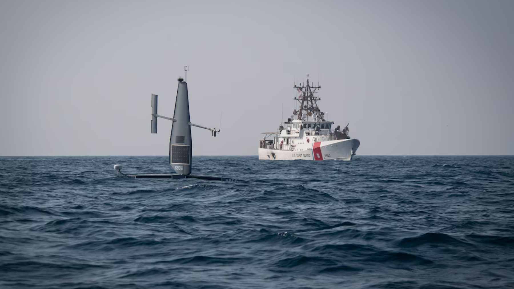 A 33-foot Saildrone autonomous vessel patrolling the open waters of the Great Lakes to monitor maritime traffic and border security.