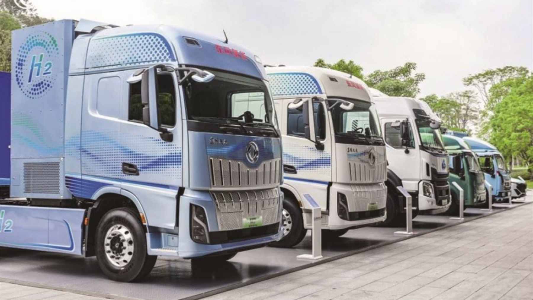 A heavy-duty Dongfeng hydrogen fuel-cell truck parked at a modern refueling station, highlighting its potential for long-haul logistics.