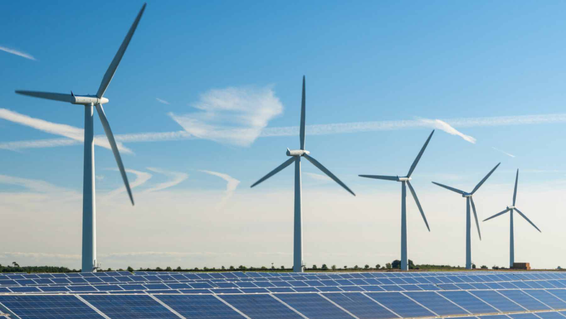 Renewable energy infrastructure, including solar panels and wind turbines, representing the expansion of the U.K. clean energy grid.