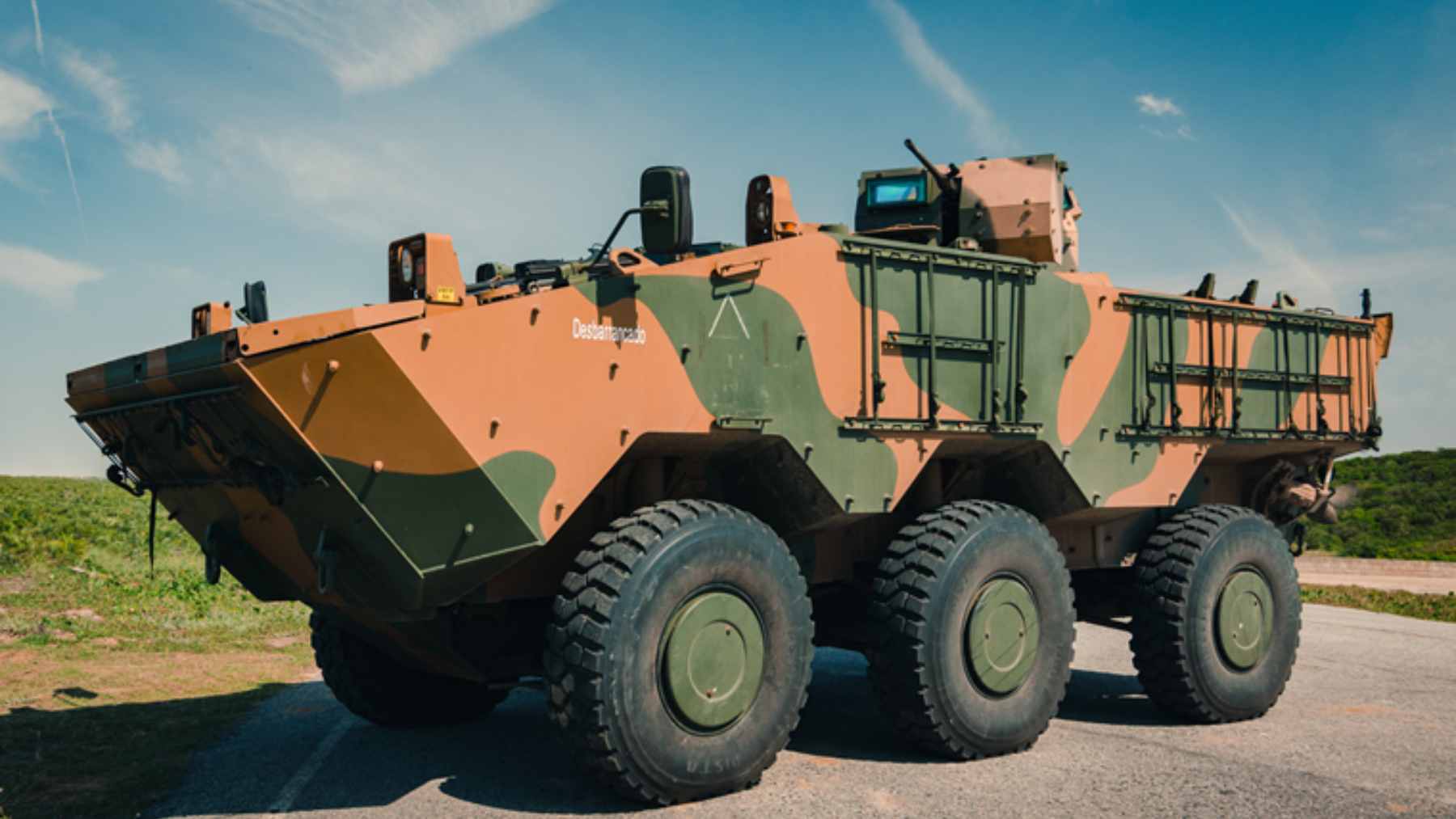 A Brazilian Guarani 6x6 armored vehicle navigating through a flooded urban area during a disaster response operation.