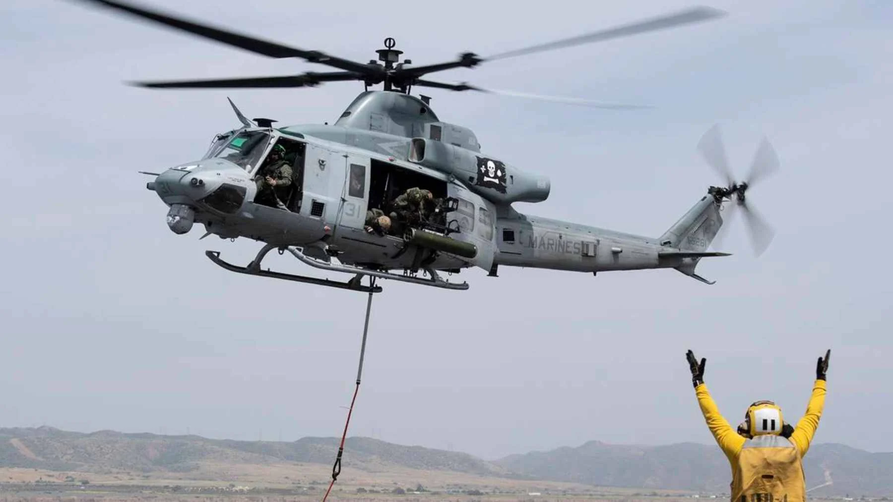 A US Marine UH-1Y Venom helicopter in flight, demonstrating its role as an airborne command hub for tactical FPV drones.