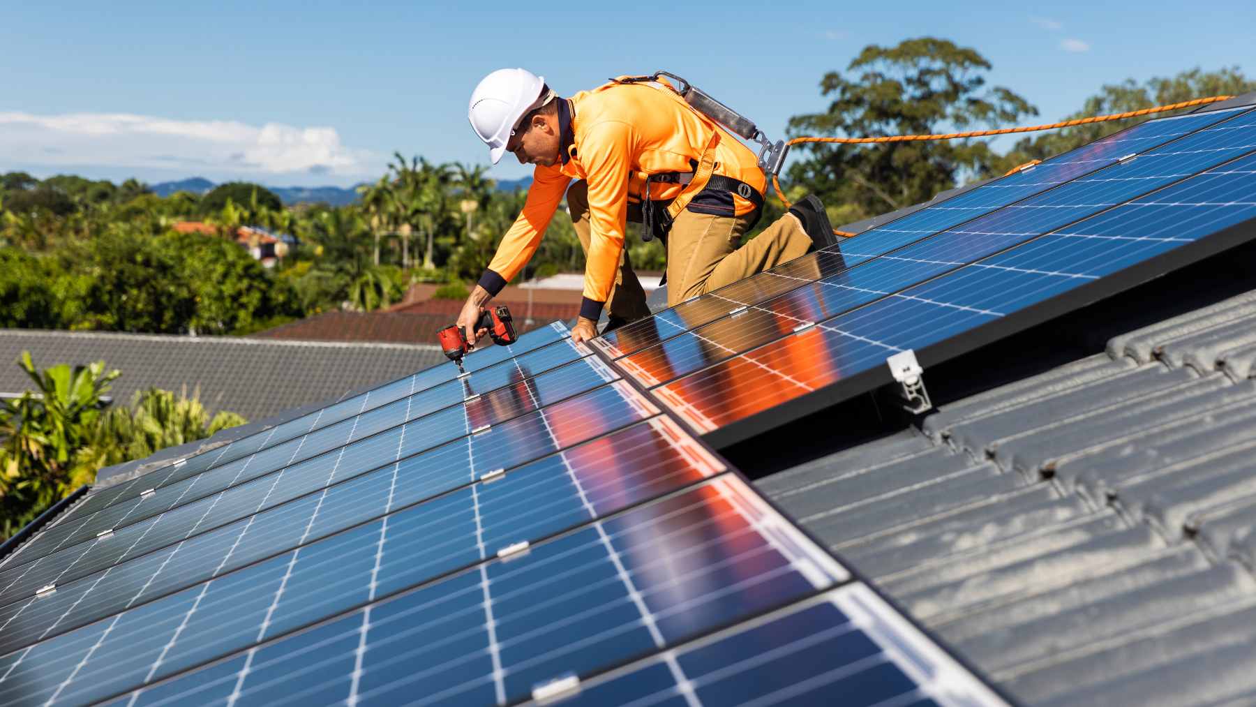 A portable home battery unit set up on an apartment balcony next to a small solar panel array.