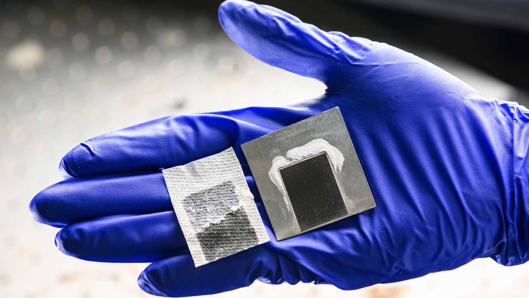 A researcher demonstrating a solar-thermal panel that uses laser-etched metal to evaporate seawater and collect solid salt crystals.